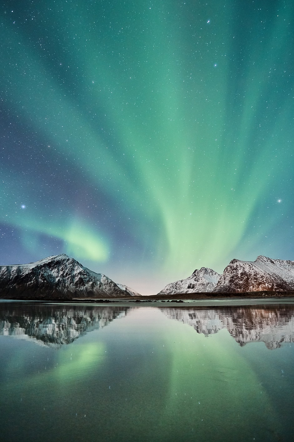 Noorderlicht boven besneeuwde bergen in Fins Lapland
